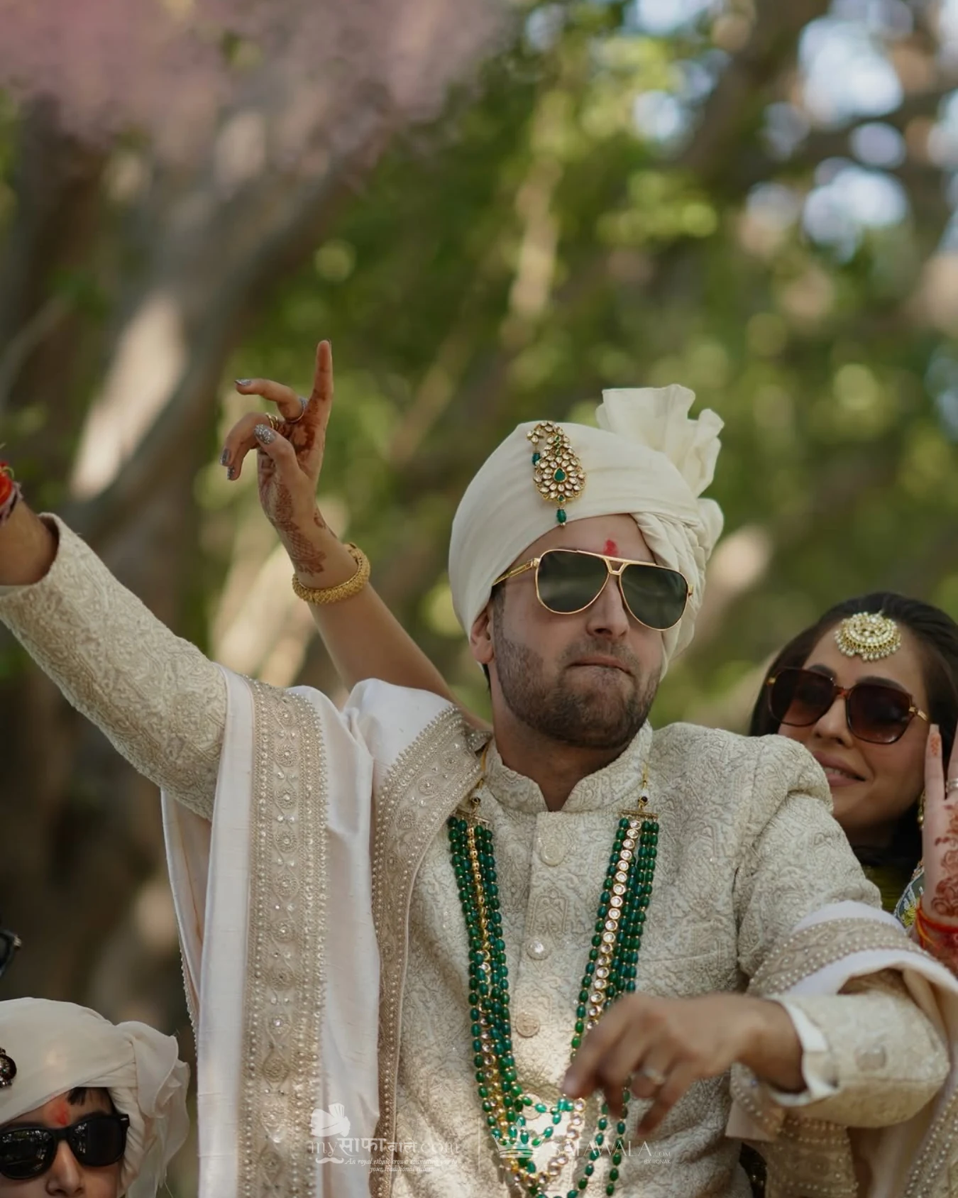 Groom in an ivory wedding safa with emerald jewellery for pagri tying professional in Malé